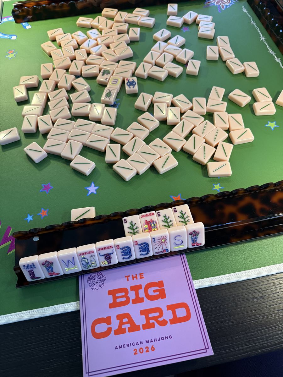 Mahjong tiles on green mat with tortoise rack